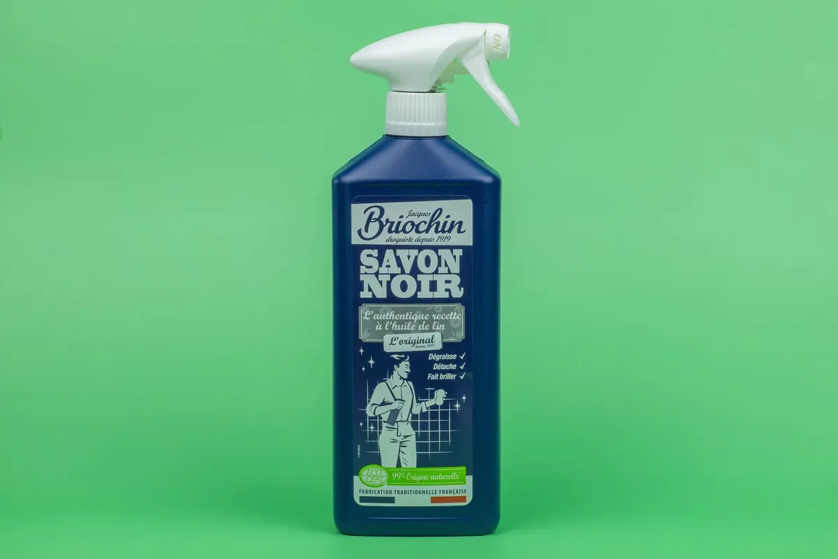 Savon noir liquide et vaporisateur posés sur un plan de travail.