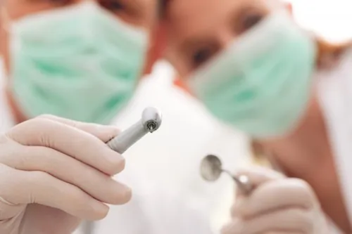 Dentistes avec masques tenant des instruments dentaires.