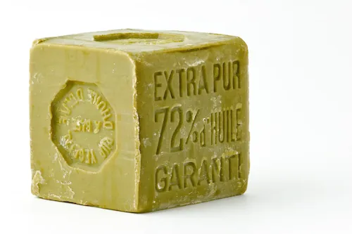Savon cube vert inscriptions dorées « Extra Pur ».