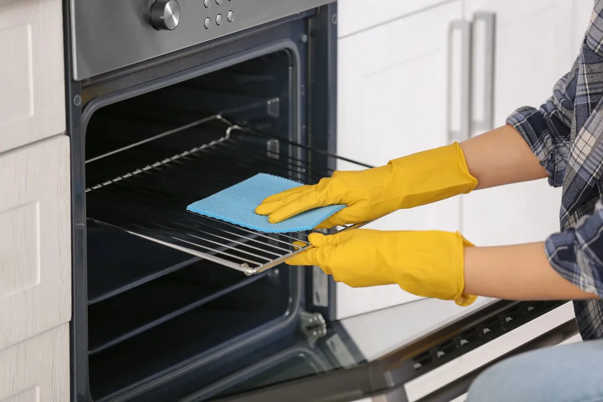 Nettoyage de four avec des gants jaunes.